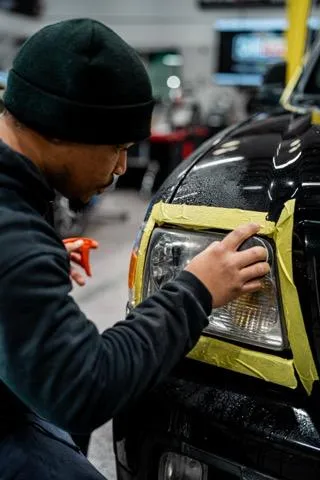 Sanding an oxidized headlight during T&T Touch headlight restoration in Lewisville, NC