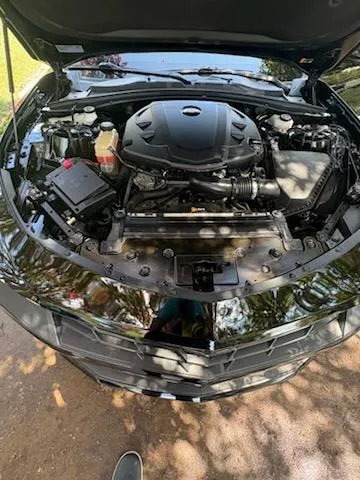 Detailed engine bay of a black car after professional mobile detailing in Lewisville, NC
